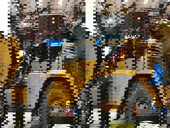 Bilete av nokon som arbeider i motoren på ei anleggsmaskin