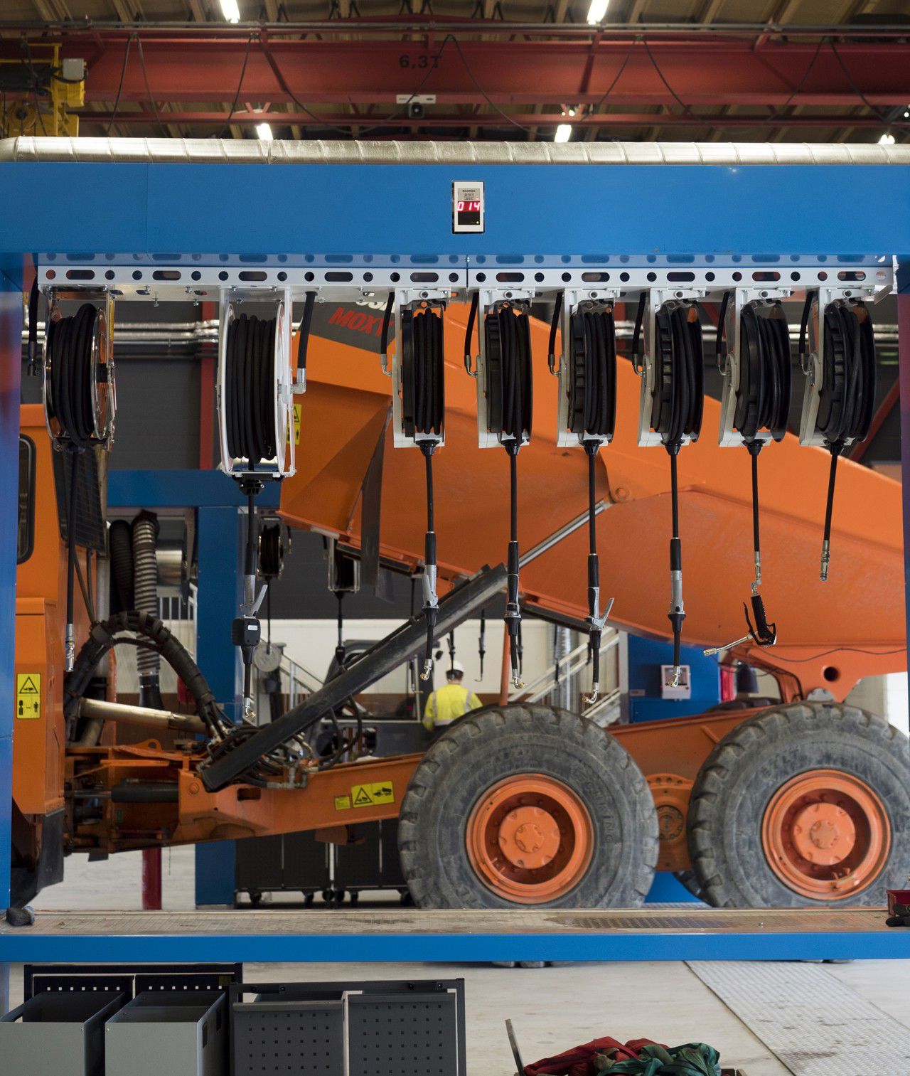 Bilete av verksted med moderne utstyr og anleggsmaskindelar.